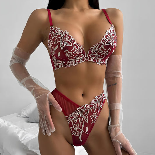 Woman wearing a red mesh 2-piece lingerie set with white embroidery, posing on a white background