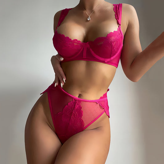 Woman wearing a pink mesh 2-piece lingerie set with embroidery, posing on a white background