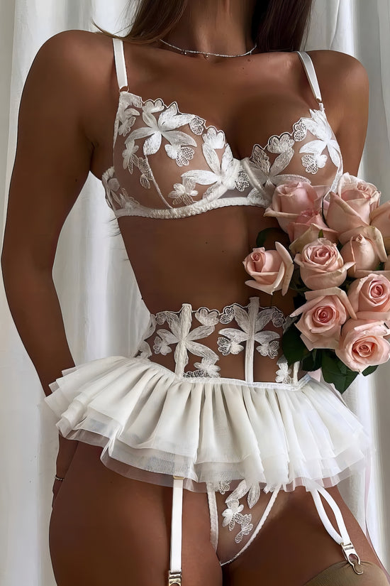 Woman wearing a white mesh 2-piece lingerie set with embroidery, posing on a white background