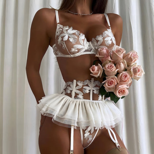 Woman wearing a white mesh 2-piece lingerie set with embroidery, posing on a white background