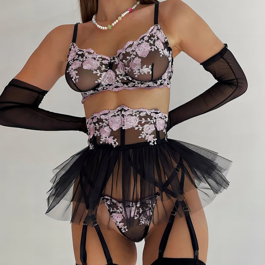 Woman wearing a black mesh 2-piece lingerie set with purple embroidery, posing on a white background