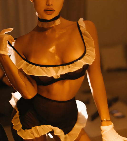 Woman wearing a luxur black and white mesh 3-piece lingerie set with pink floral embroidery, including underwire bra, garter belt, and matching thong