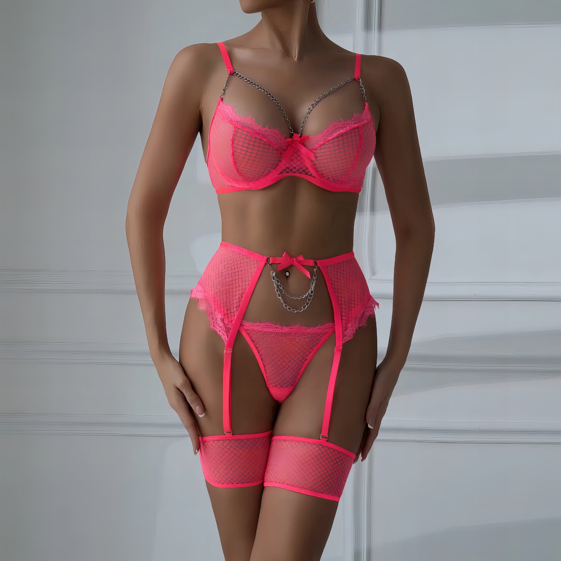 Woman wearing a luxury pink mesh 3-piece lingerie set with embroidery, including underwire bra, garter belt, and matching thong