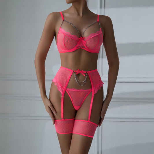 Woman wearing a luxury pink mesh 3-piece lingerie set with embroidery, including underwire bra, garter belt, and matching thong