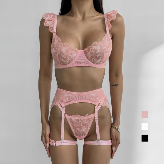 Woman wearing a luxury pink mesh 3-piece lingerie set with embroidery, including underwire bra, garter belt, and matching thong 