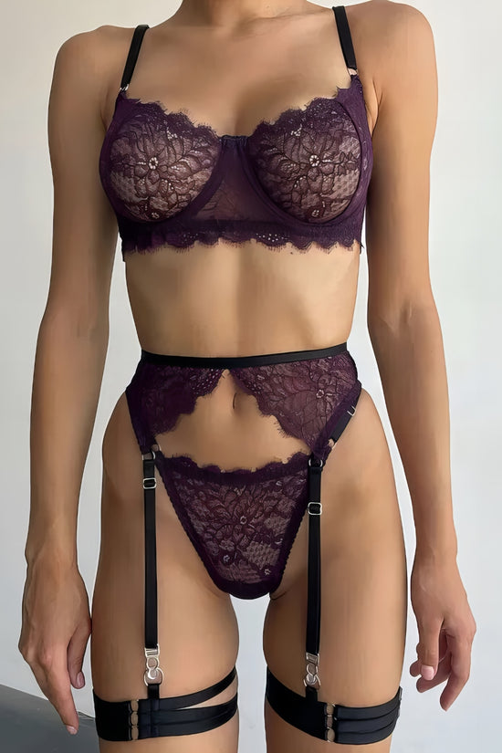Woman wearing a luxury purple mesh 3-piece lingerie set with embroidery, including underwire bra, garter belt, and matching thong 