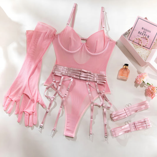 Woman wearing a luxury pink mesh 3-piece lingerie set with embroidery, including underwire bra, garter belt, and matching thong