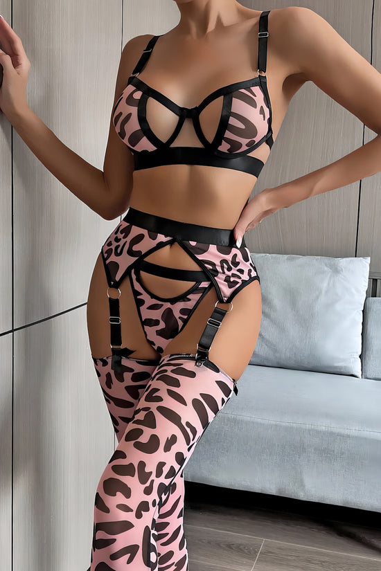 Woman wearing a luxury pink mesh 3-piece lingerie set with embroidery, including underwire bra, garter belt, and matching thong