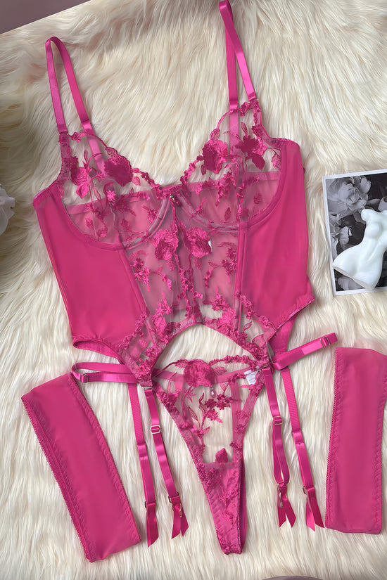 A pink mesh 2-piece lingerie set with embroidery, posing on a white background