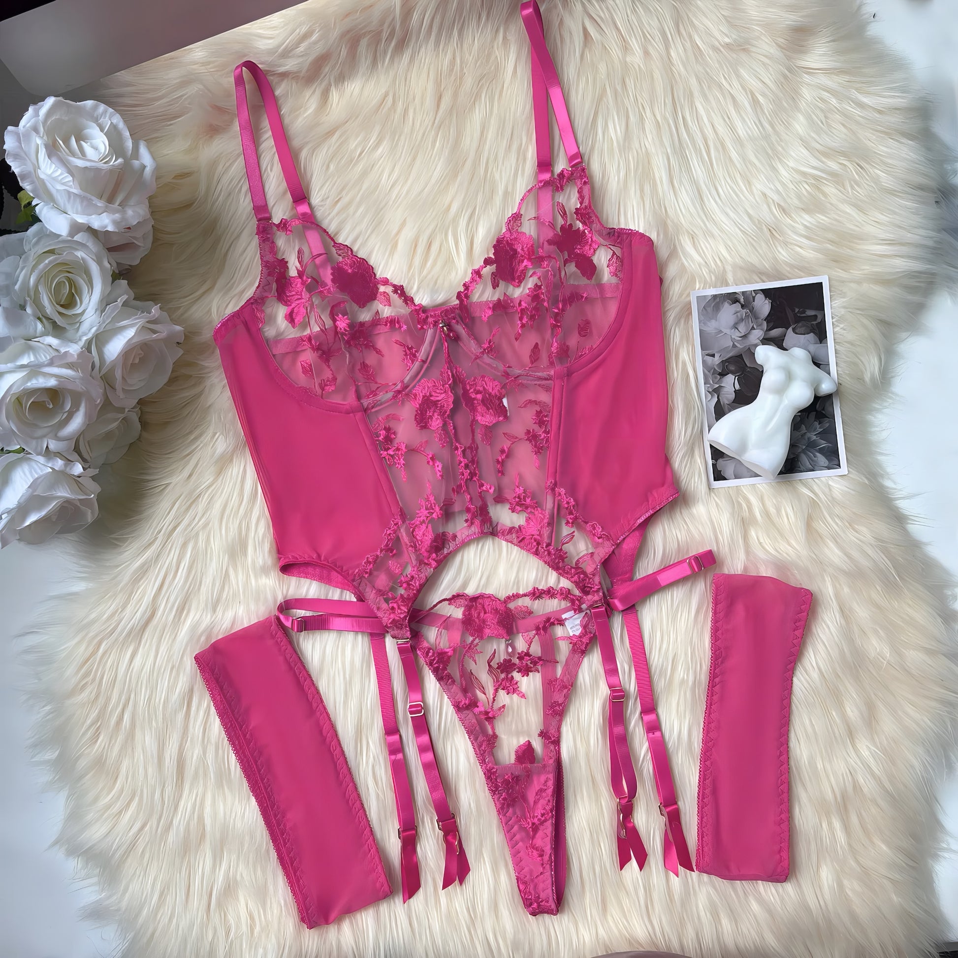 A pink mesh 2-piece lingerie set with embroidery, posing on a white background