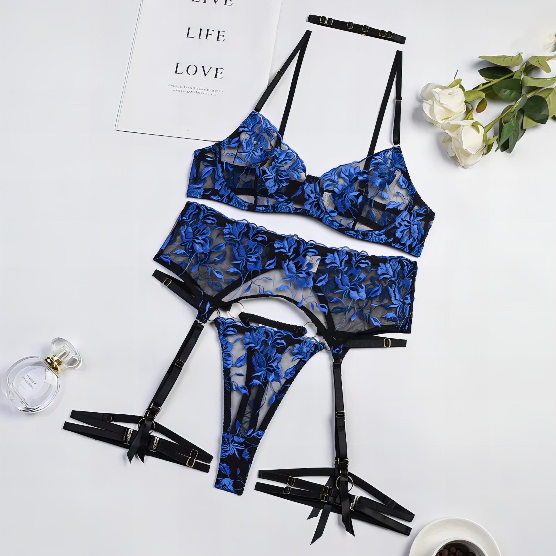 A luxury blue mesh 3-piece lingerie set with embroidery, including underwire bra, garter belt, and matching thong